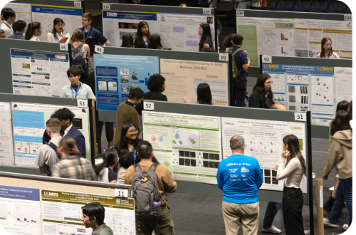 Crowded academic poster session in a conference hall with masked attendees