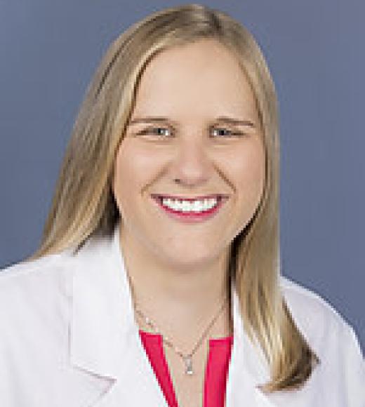 Headshot photo, smiling female doctor with blonde hair and white coat