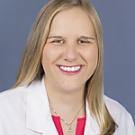 Headshot photo, smiling female doctor with blonde hair and white coat