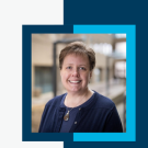 Portrait photograph of a smiling middle-aged woman in a navy blazer framed by blue-teal graphic.